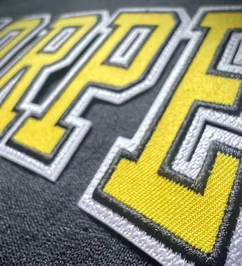 Embroidery Services Professional embroidery machine in action stitching detailed logo design on fabric